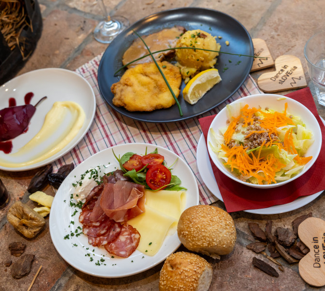 Different Slovenian dishes on four plates on the table.