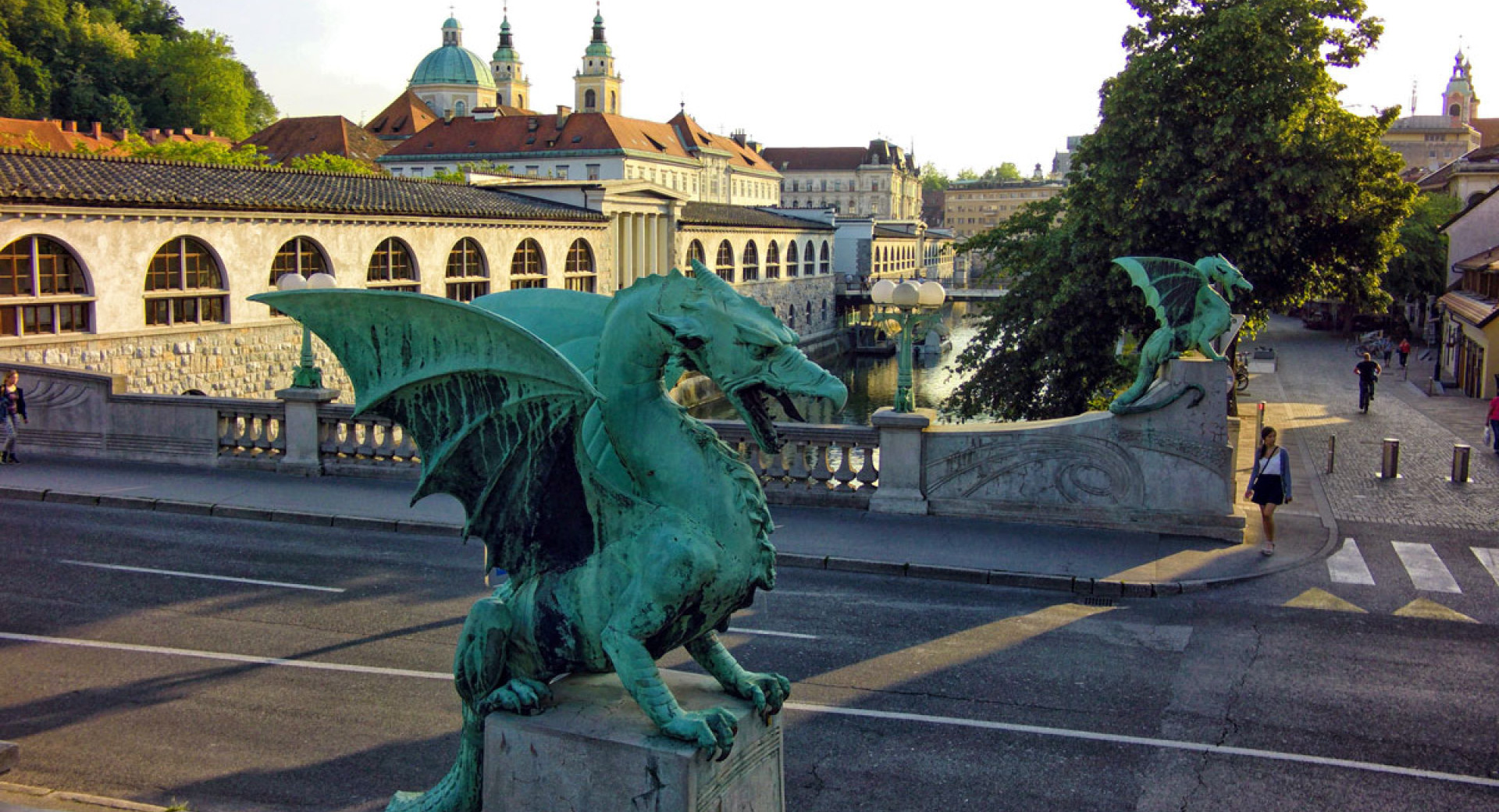 Zmaja na Zmajskem mostu. V ozadju arkade Plečnikovih tržnic.