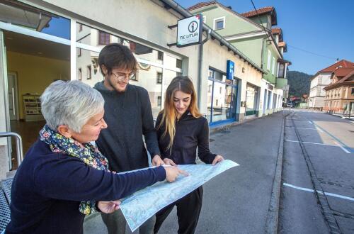 Drei Personen betrachten eine Karte vor dem Touristischen Informationszentrum Litija.