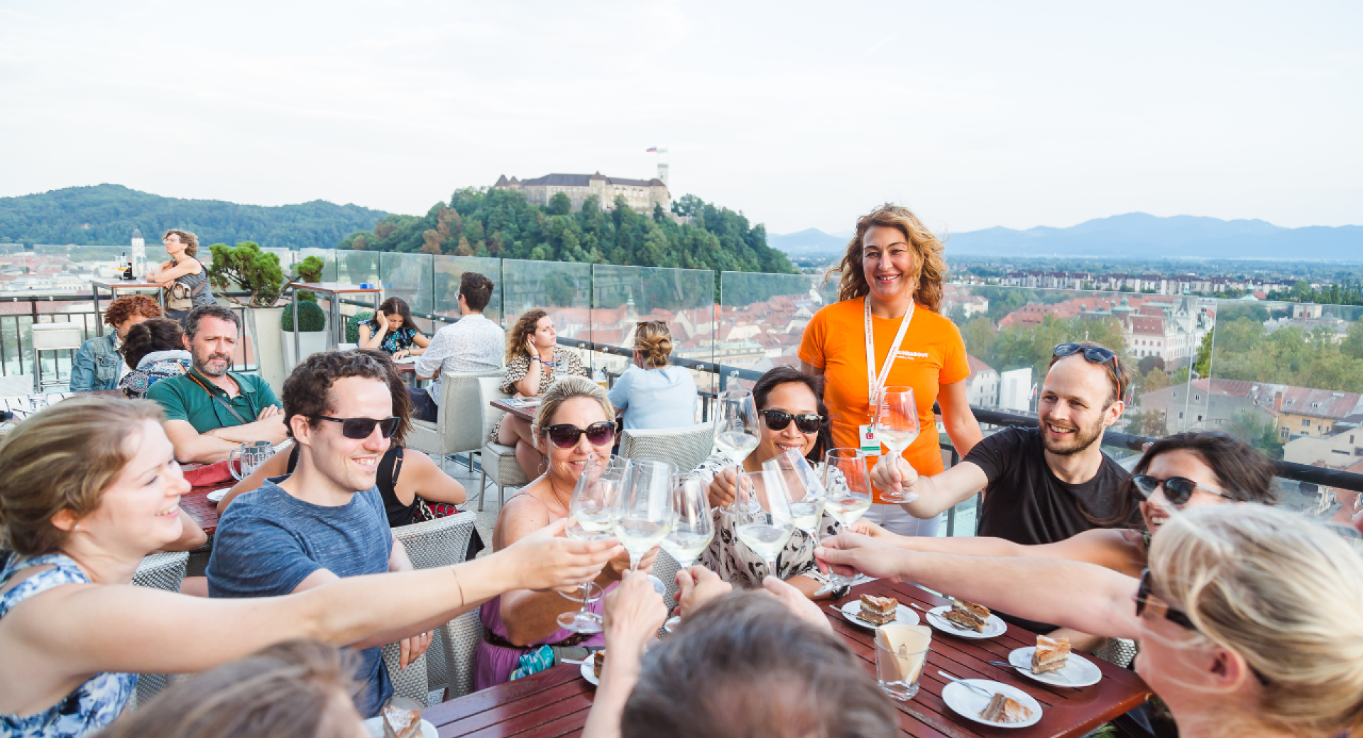 Persone che brindano con il vino, con un castello su una collina sullo sfondo.
