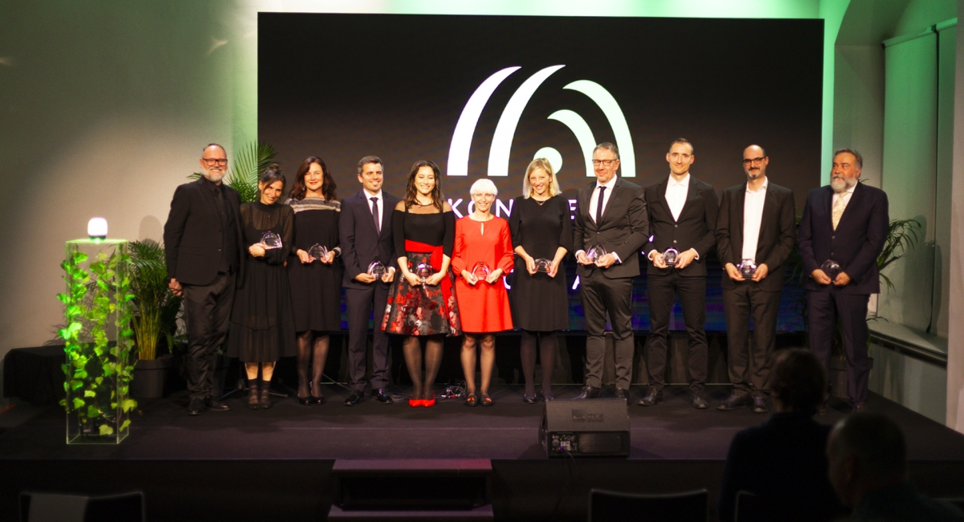 Skupina ljudi drug ob drugem stoji na odru.