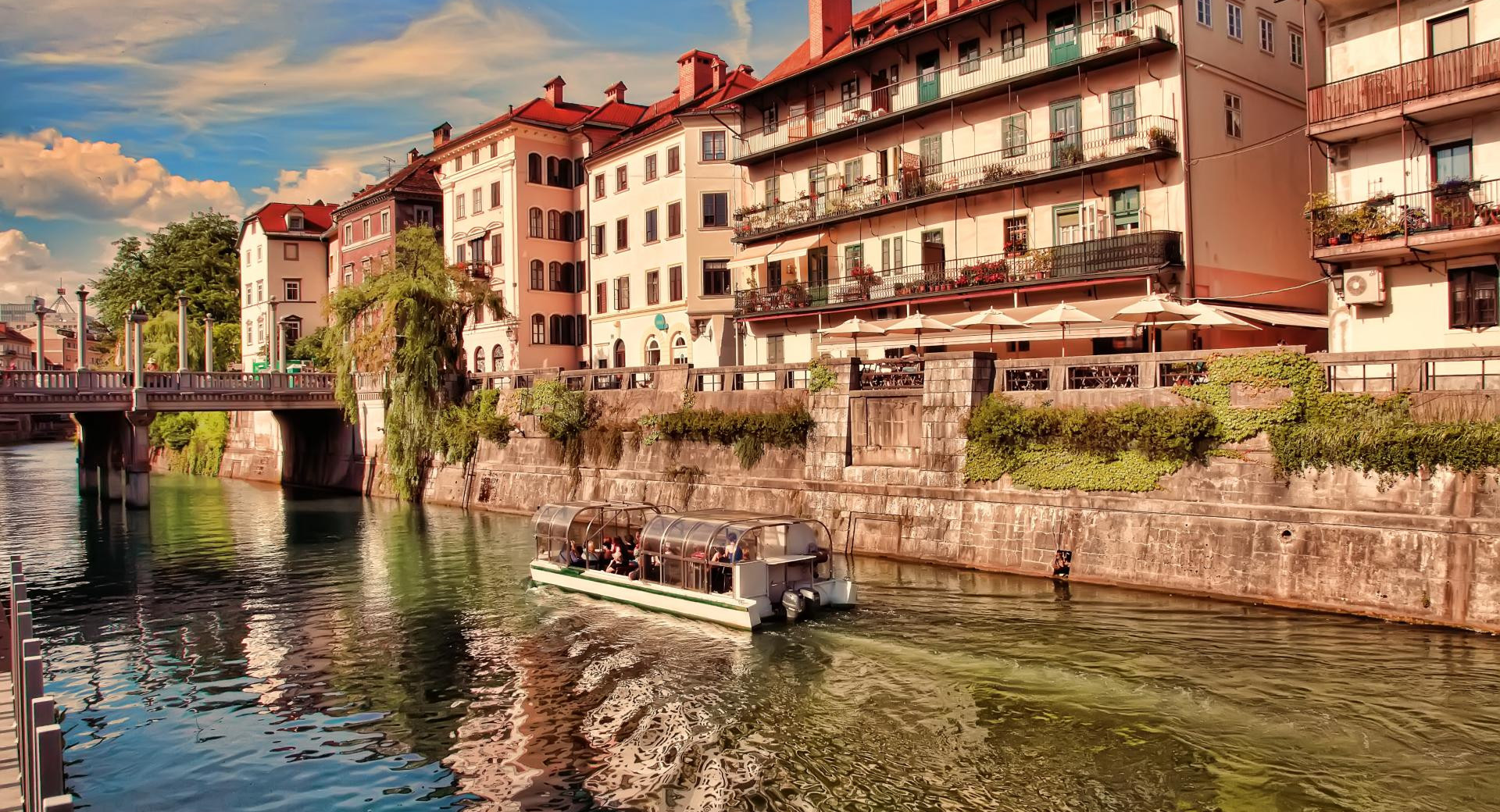 Ladjica na reki, na nabrezjih mestne hiše in most cez reko.