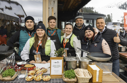 Skupina ljudi pred naborom pripravljenih jedi za postrežbo.