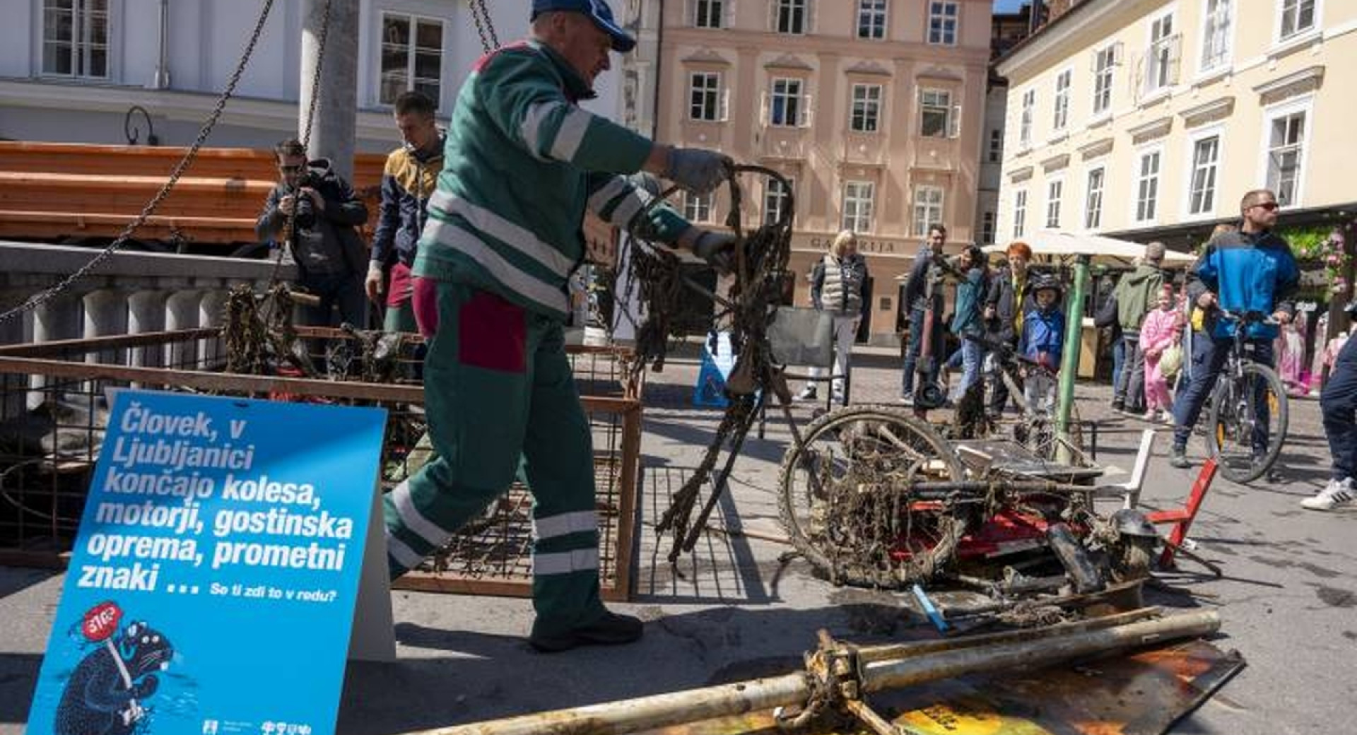 Moški v delovnih oblačilih, ob njem so naložena odpadna kolesa.
