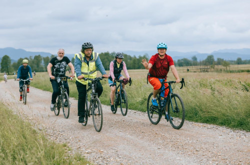A small group of cyclists on a gravel road.