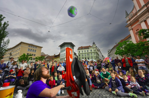Predstava na trgu z nastopajocimi in obcinstvom.
