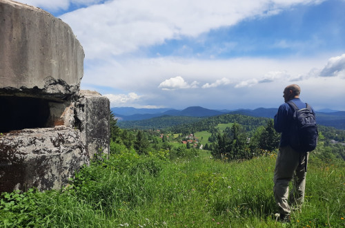 Obiskovalec na travniku ob ostalinah bunkerja.