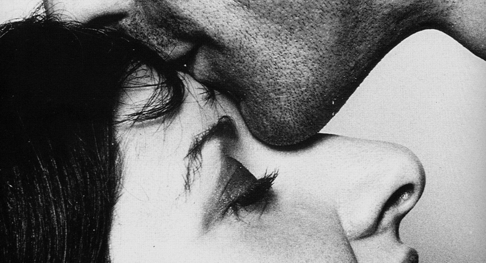 Moški poljublja žensko na čelo.