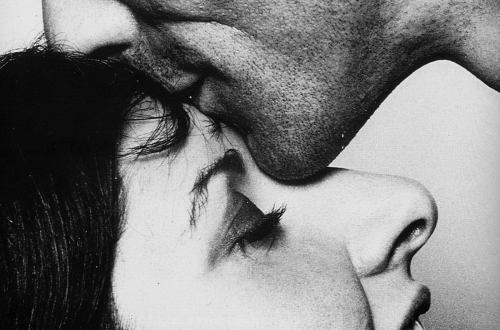 Moški poljublja žensko na čelo.