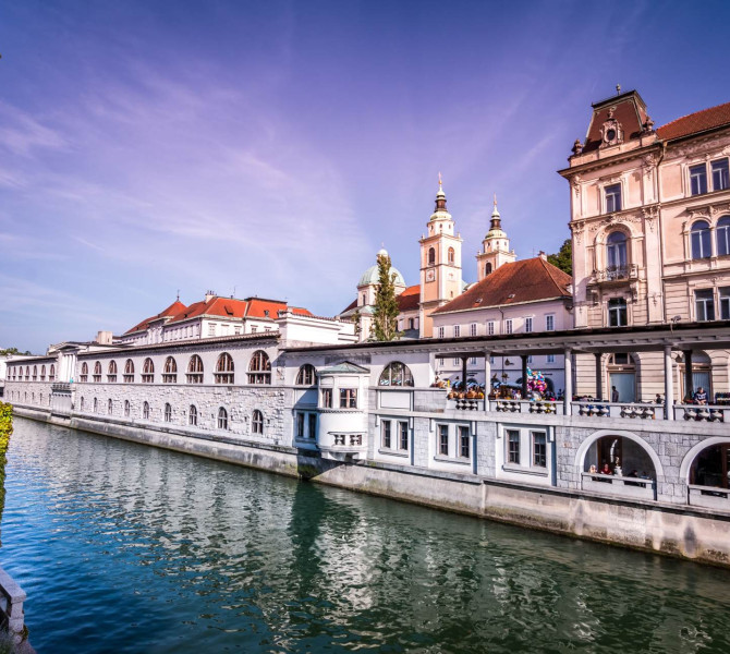 Plečnik-Arkaden am Fluss, im Hintergrund die Kathedrale.
