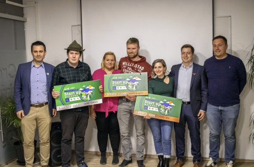 Skupina ljudi pred objektivom s tremi večjimi boni za nagrado.