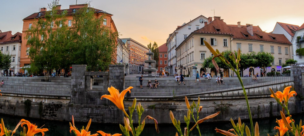 Pogled z levega strani nabrezja reke na desnega, kjer so stopnice in starinske hiše. 