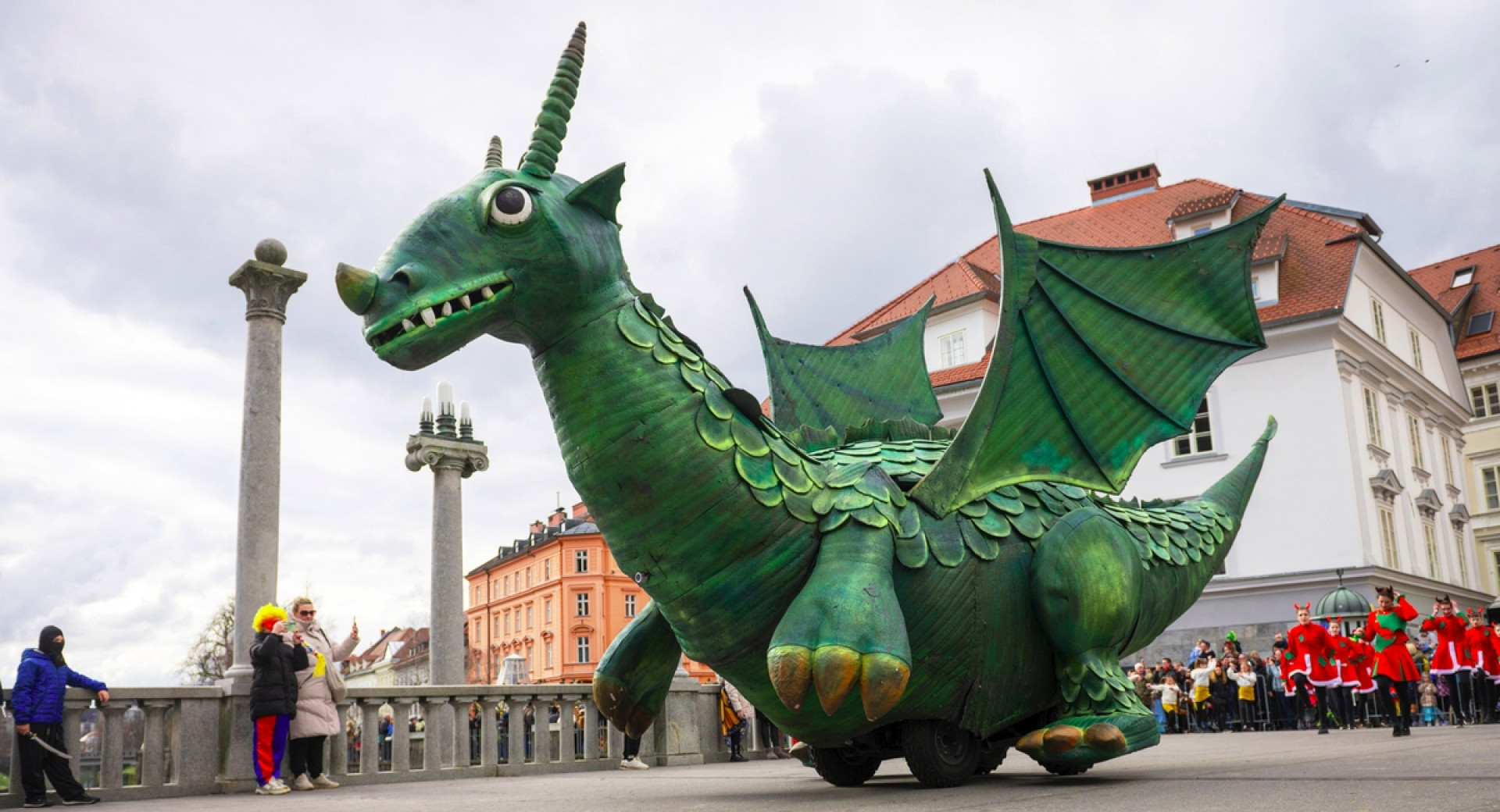 Maskota ljubljanskega zmaja na mostu med Zmajevim karnevalom v Ljubljani leta 2025.