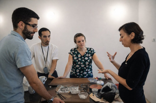 Umetnica razlaga udeležencem delavnice.