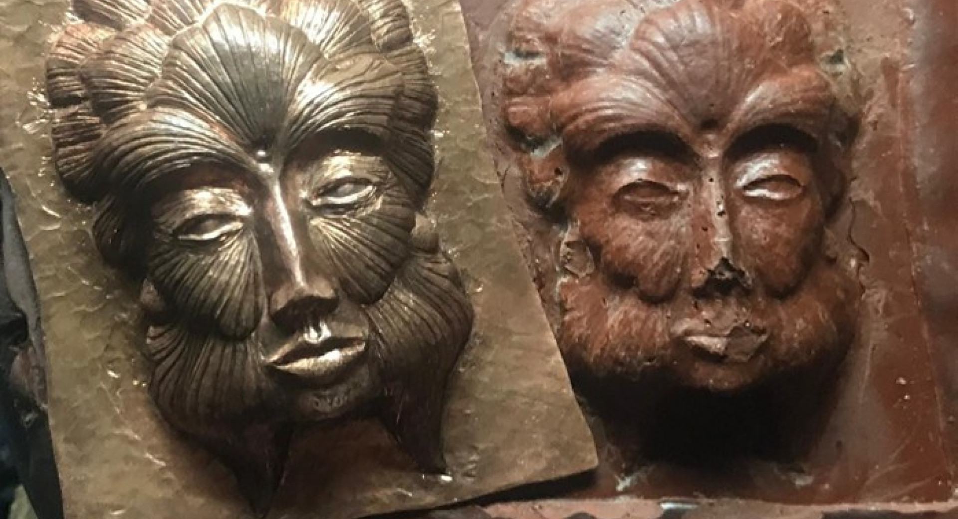 Two faces imprinted on metal.