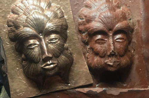Two faces imprinted on metal.