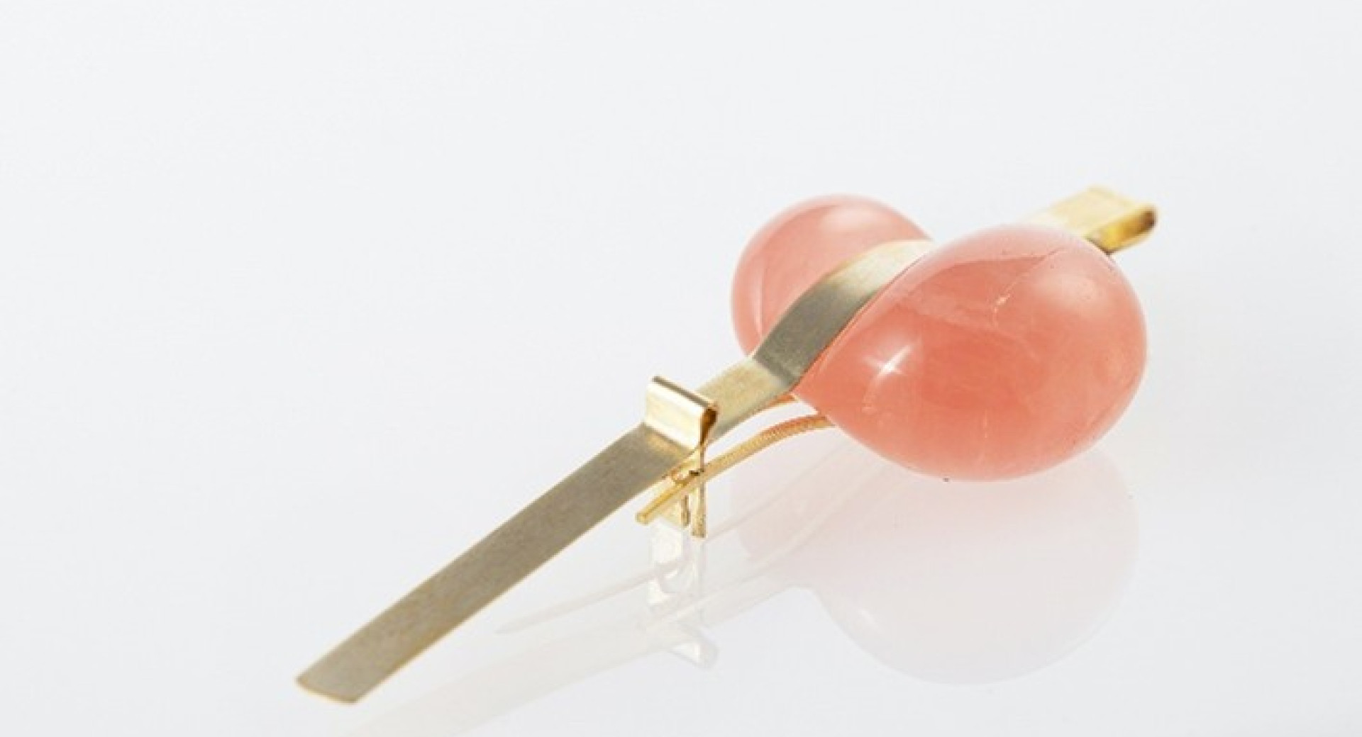 Roza kamen vpet v zlato sponko.