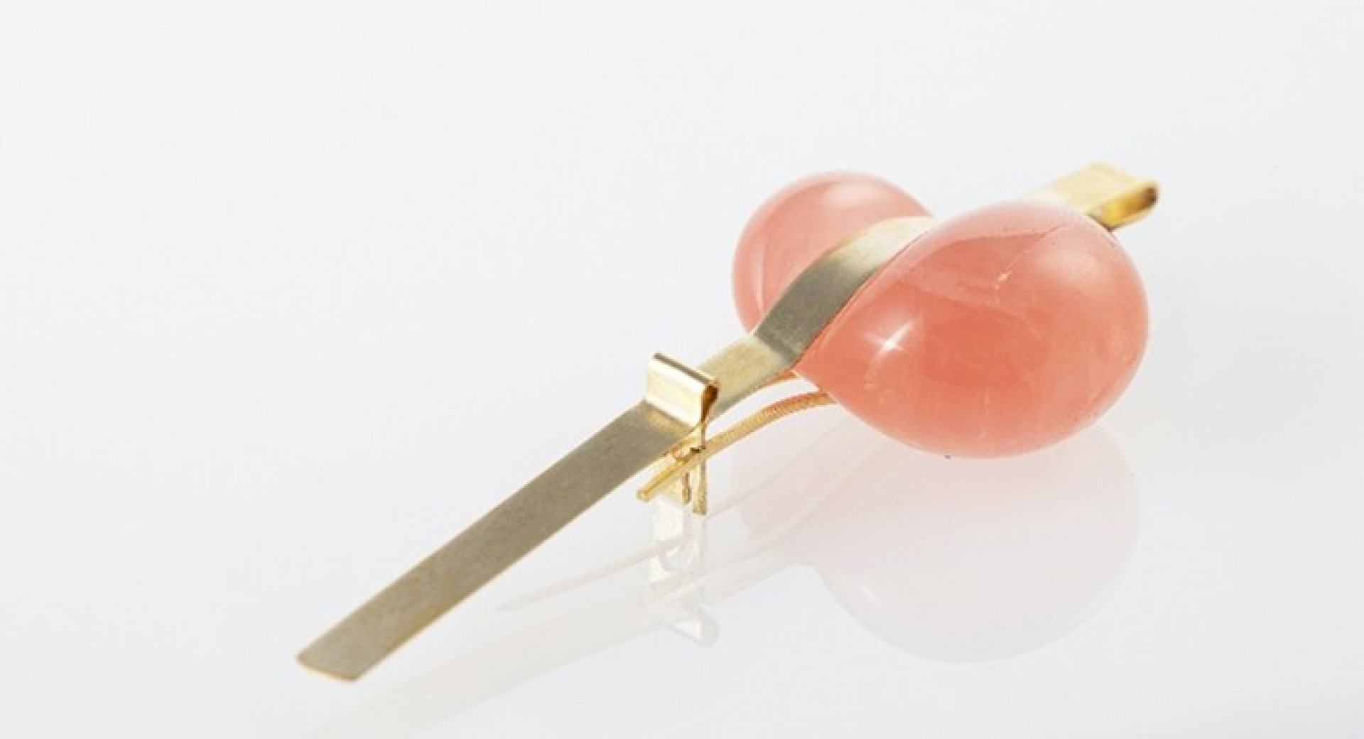 A pink stone set in a gold clip.