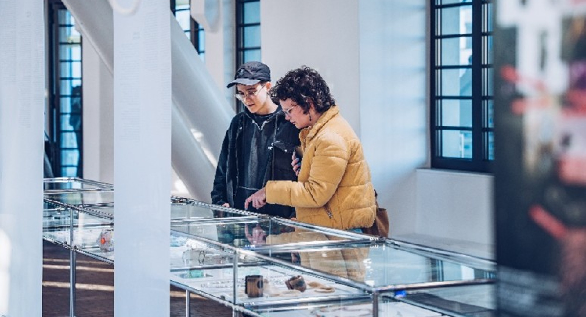 Two visitors viewing a jewellery exhibition.