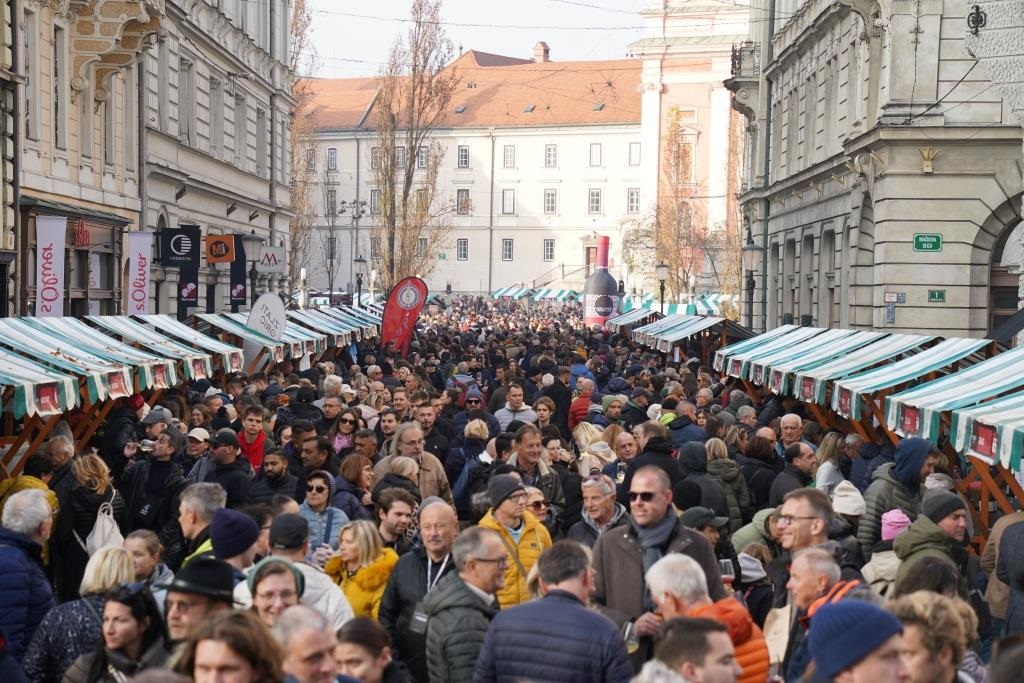 A crowd of people among the stalls in the centre of Ljubljana.