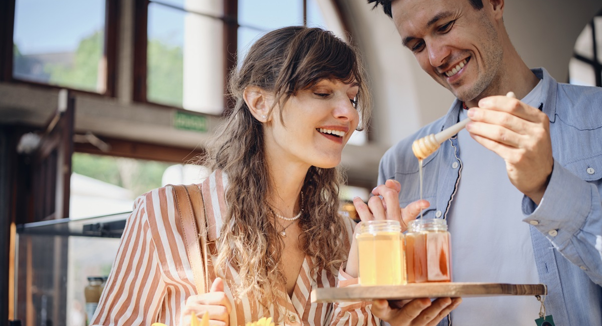 Zenska in moski si ogledujeta in obcudujeta med v steklenicki.