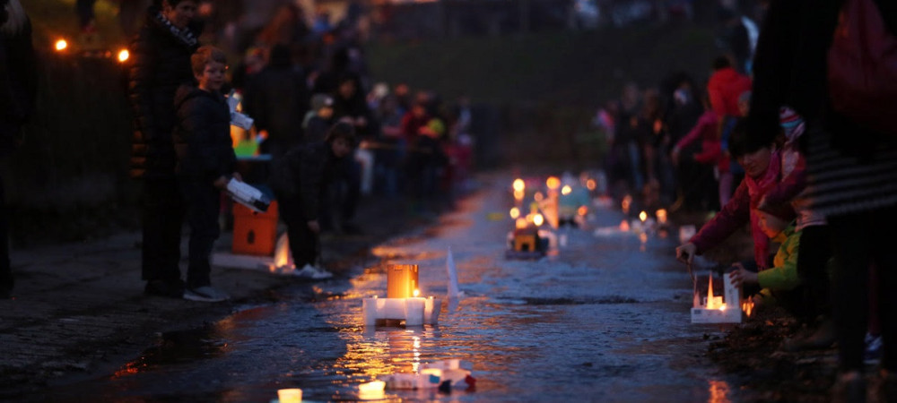 Children floating boat lanterns on the water. 