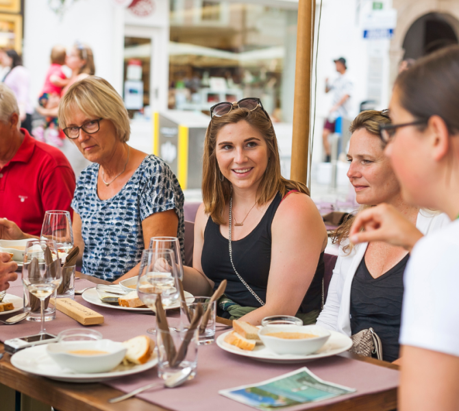 Persone sedute a tavola che mangiano.