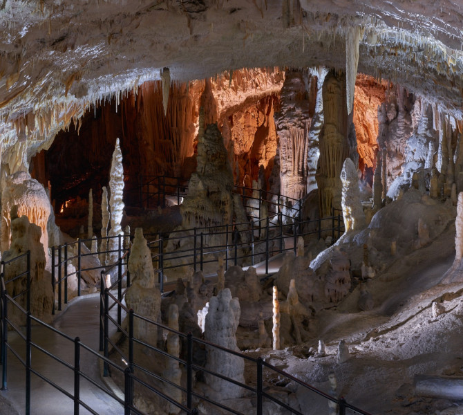 White stalactites on both sides of the walking path in the cave.