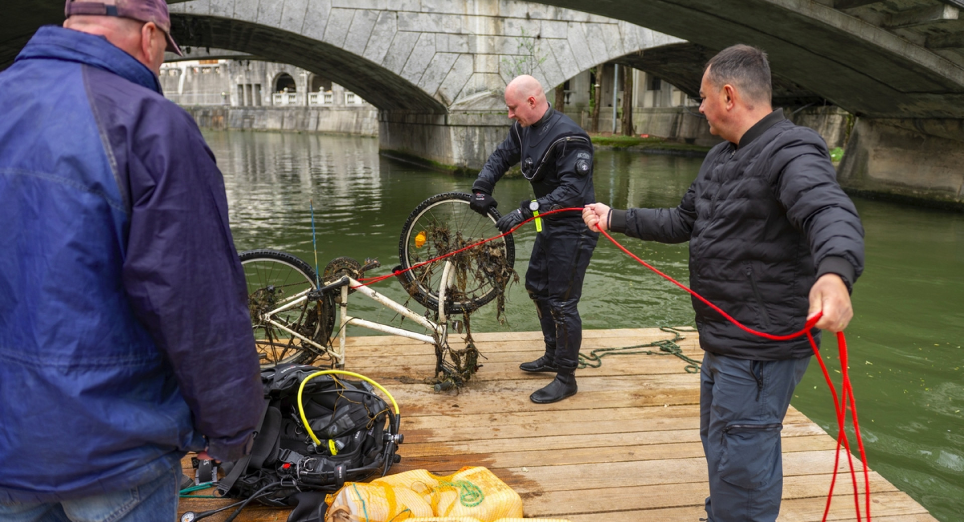 Čiščenje reke; iz nje so pravkar izvlekli kolo.