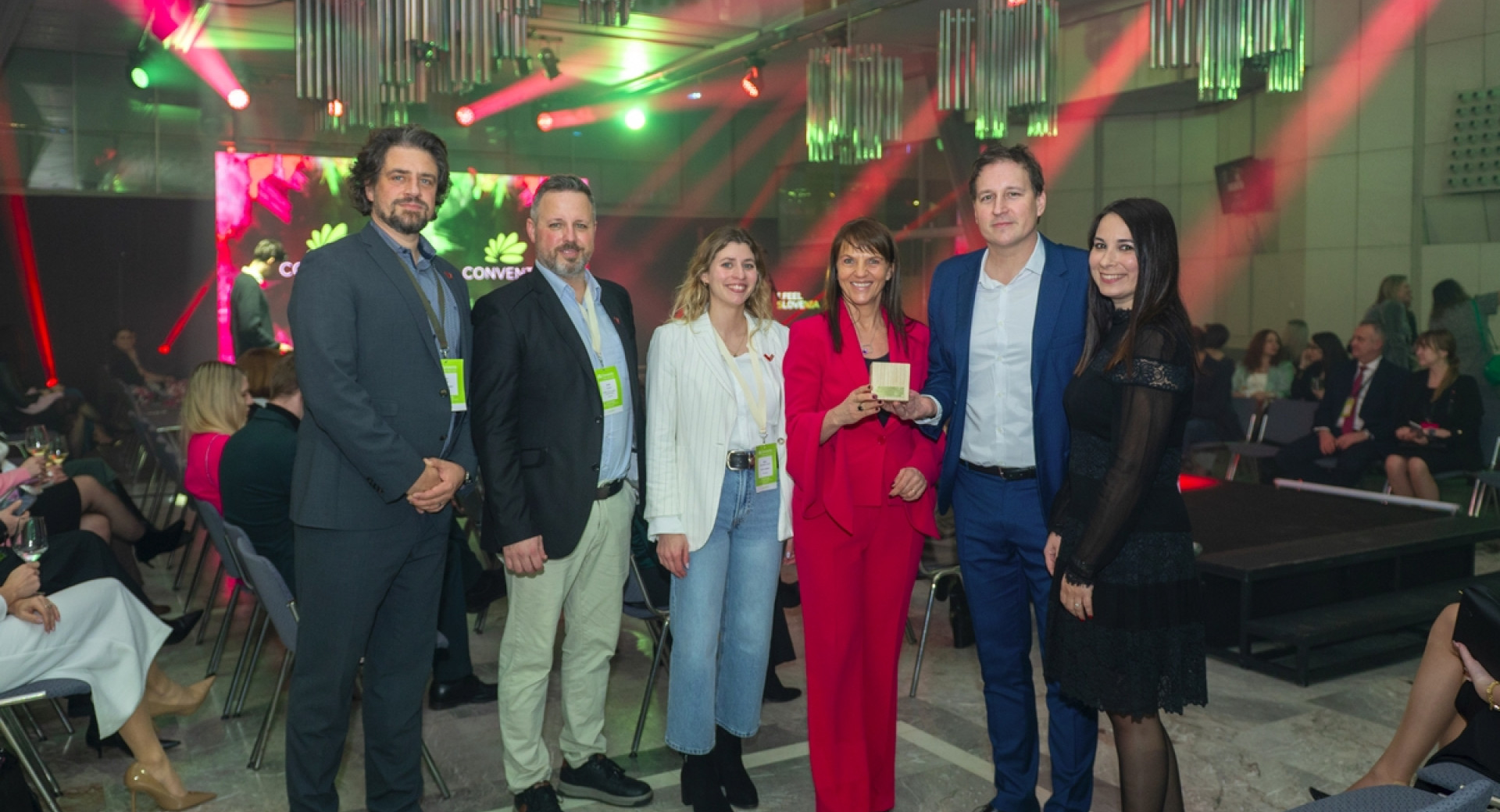 Šest oseb stoji skupaj na prireditvi.