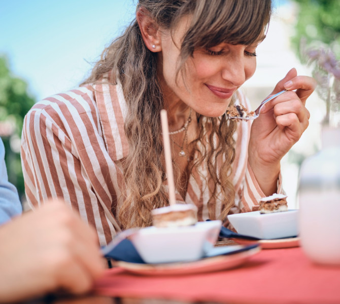 Eine Frau und ein Mann betrachten und bewundern den Honig im Glas.