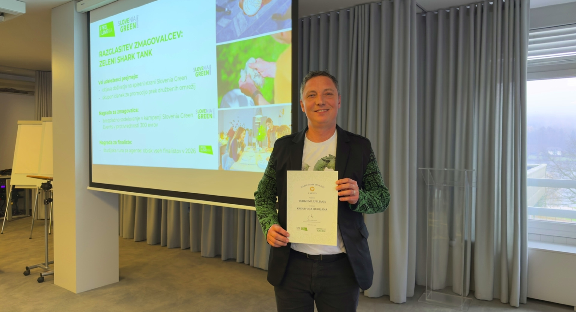 Oseba drži v roki priznanje za nagrado.