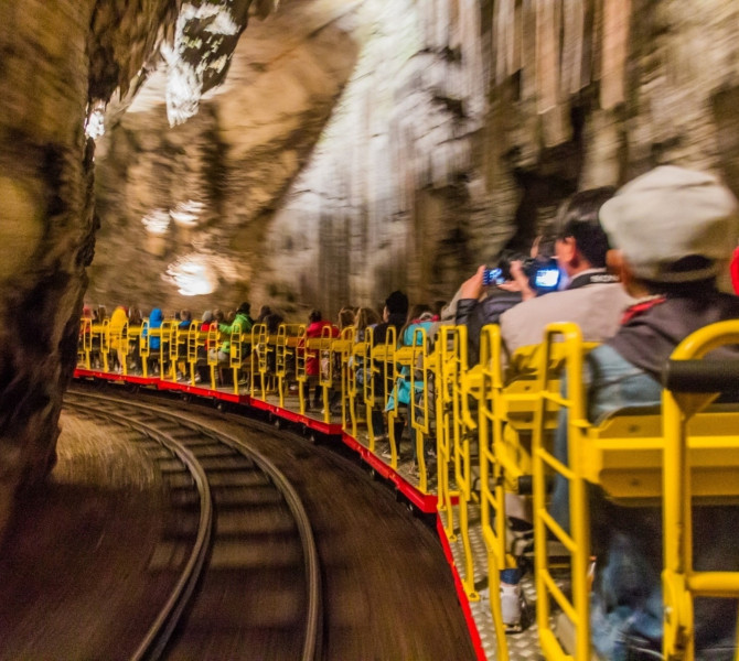 People on a train riding through the cave.