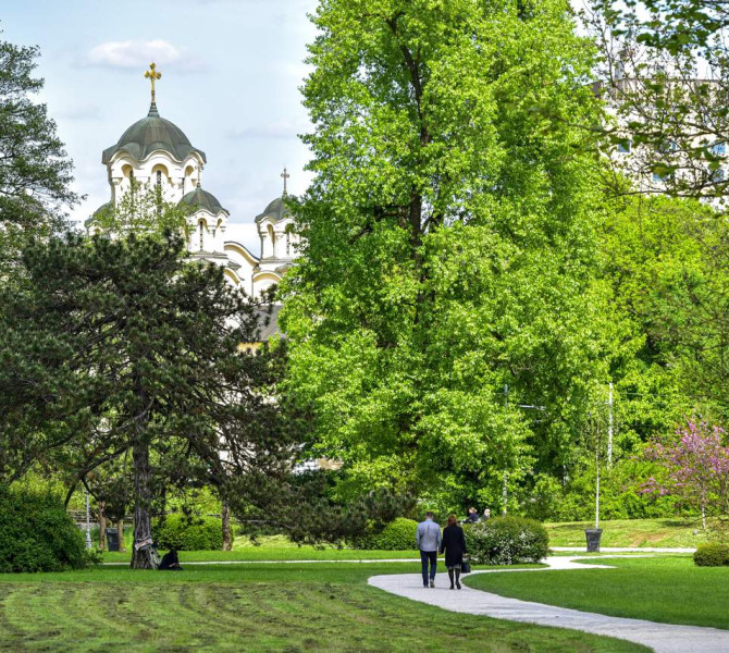 Park z drevesi, v ozadju protestantska cerkev. 