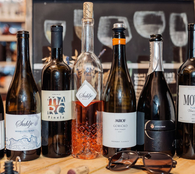 Verschiedene Weinflaschenformen mit einer Sonnenbrille daneben.