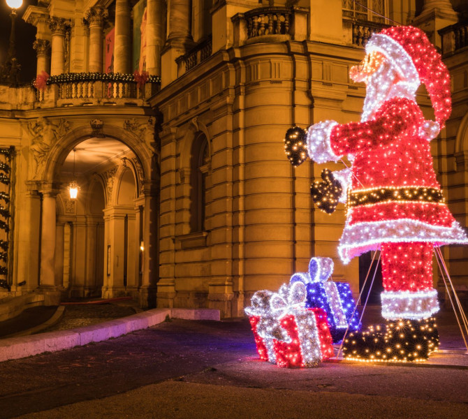 Un enorme Babbo Natale fatto di luci, posizionato sulla strada.