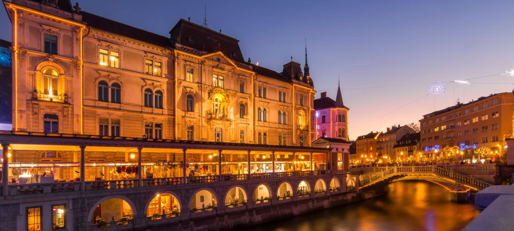 Festlich geschmückter Plečnik-Markt aus der Wasserperspektive.