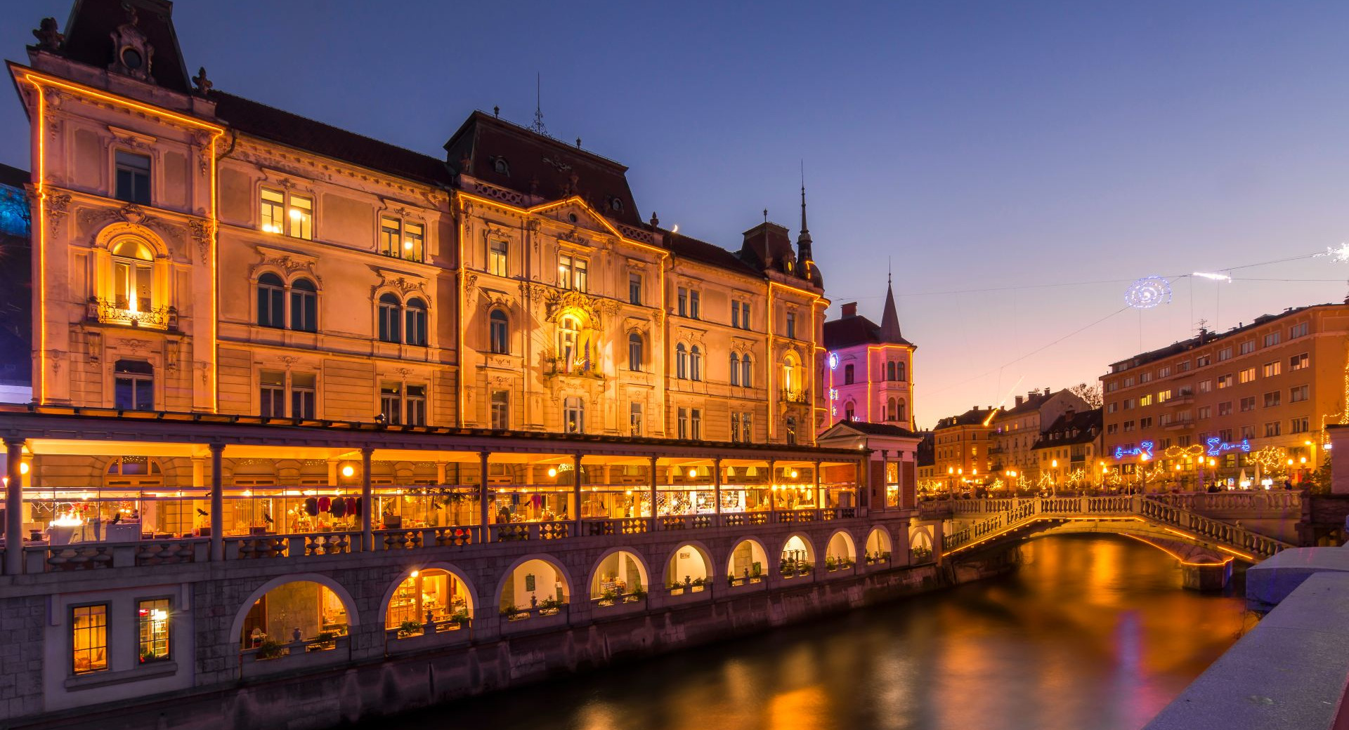 Praznično okrašene Plečnikove tržnice z vodne perspektive.