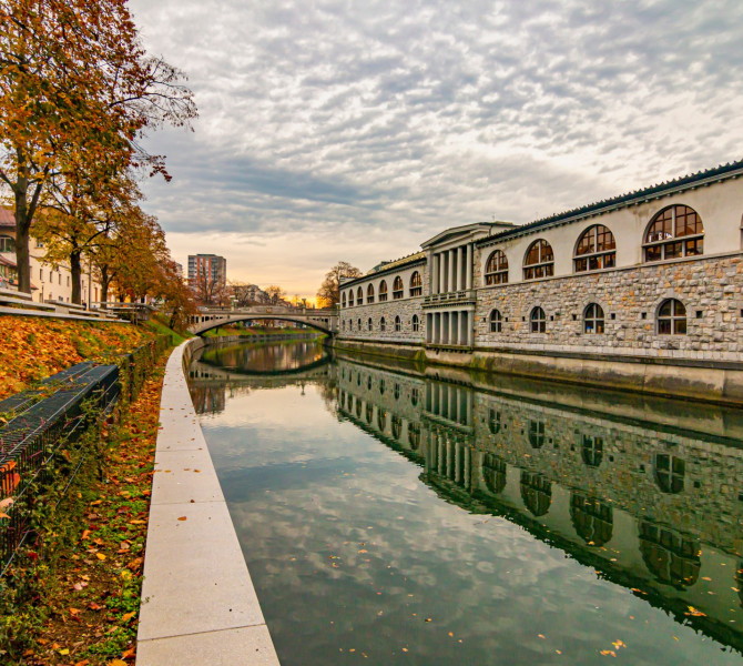 Reka skozi mesto, nabrezje v jesenskih barvah, na desni strani arkade trznice. 