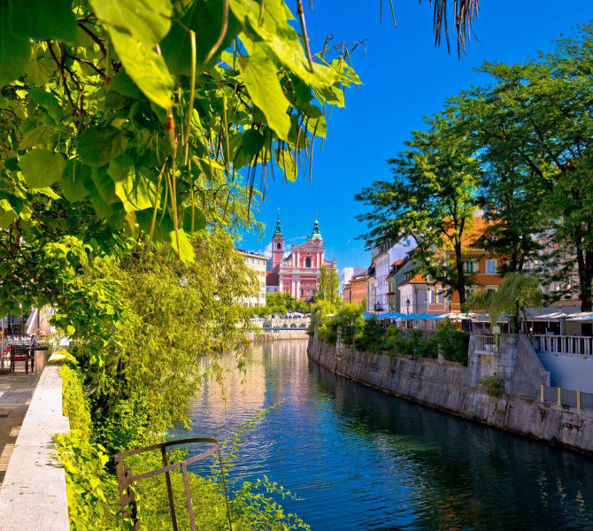 A river flowing through the city, with green embankments on both sides.