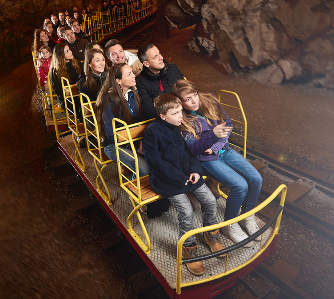 Persone sul trenino turistico nella grotta.