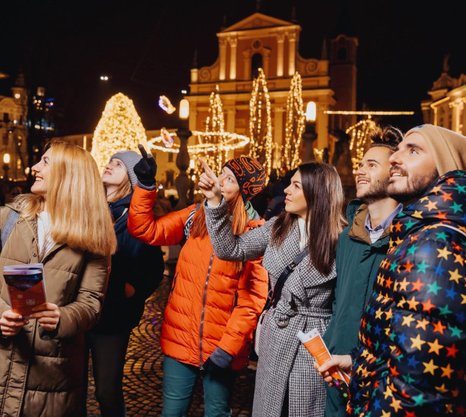 Une guide explique les décorations de fête aux touristes.