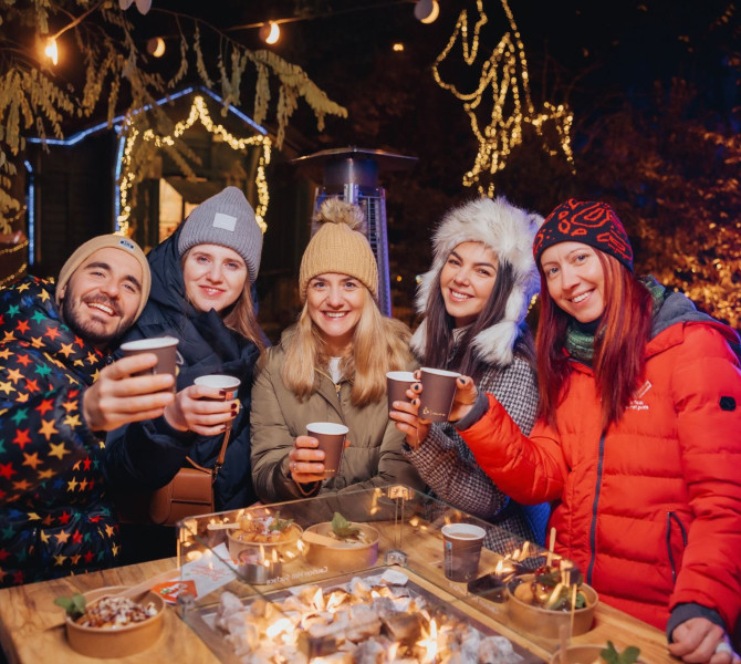 Des gens portent un toast avec du vin chaud.