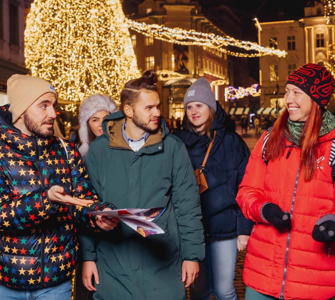 Une guide explique les décorations de fête aux touristes.