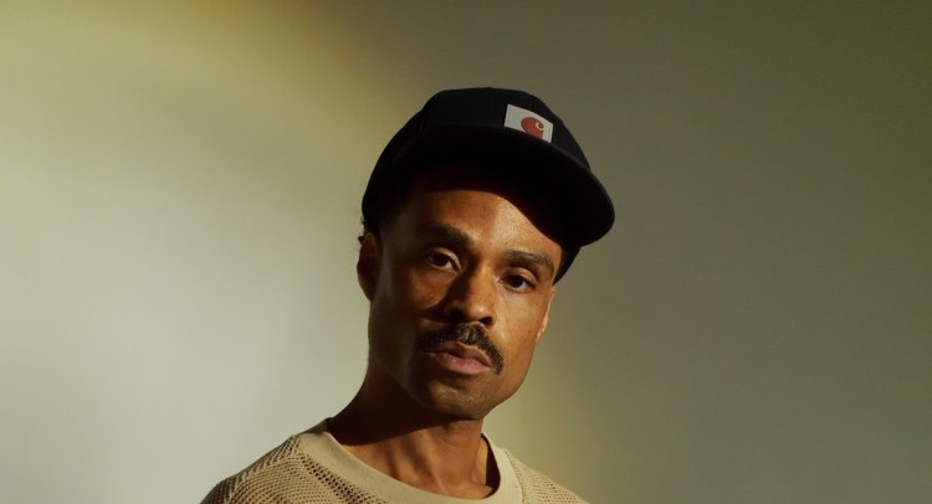 Temnopolt moski s crno cepico in belim puloverjem.