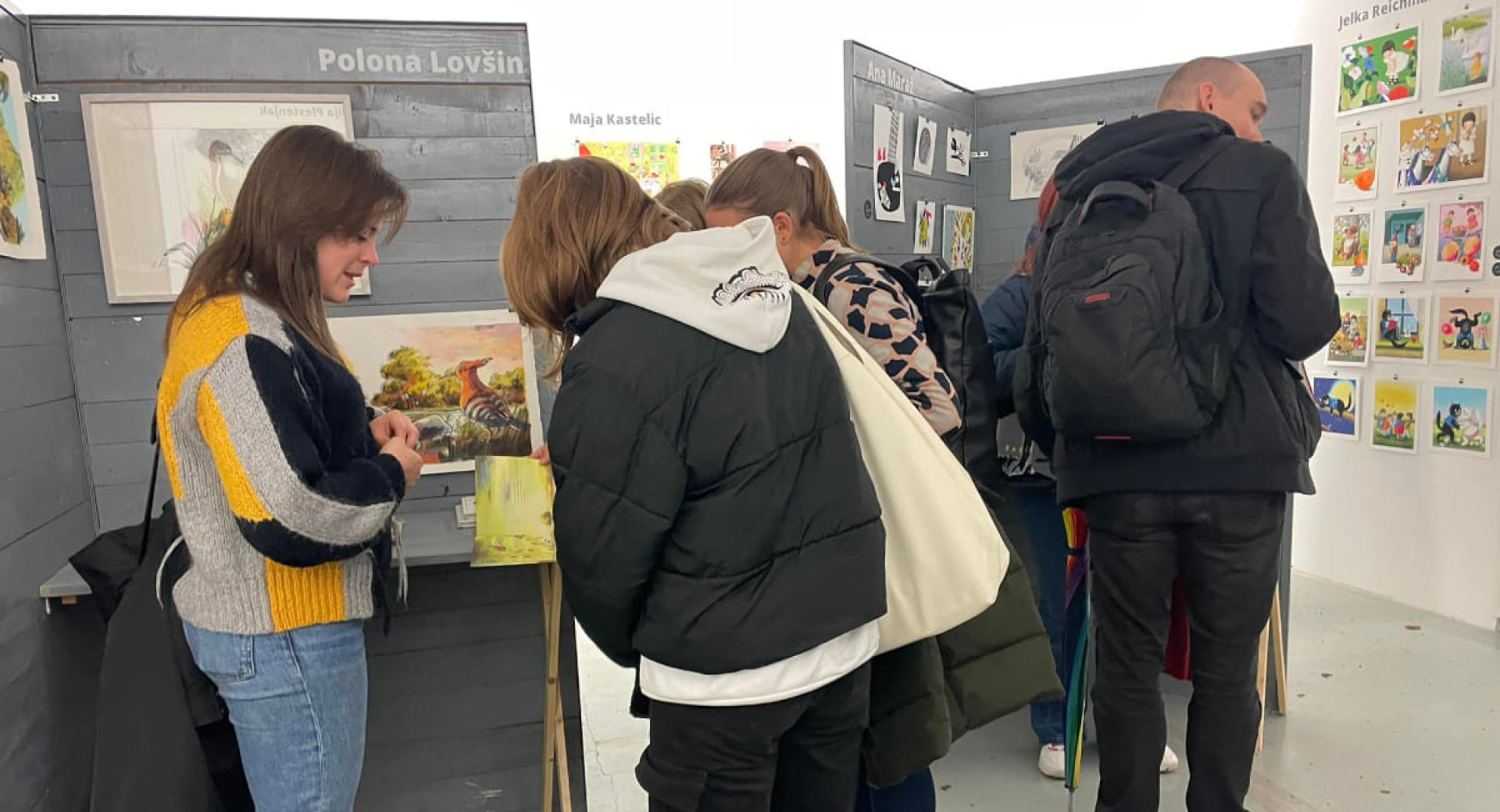 Ljudje si ogledujejo razstavo.