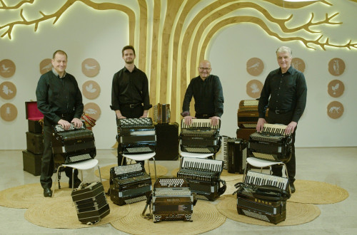 Stirje glasbeniki s hramonikami v sobi.