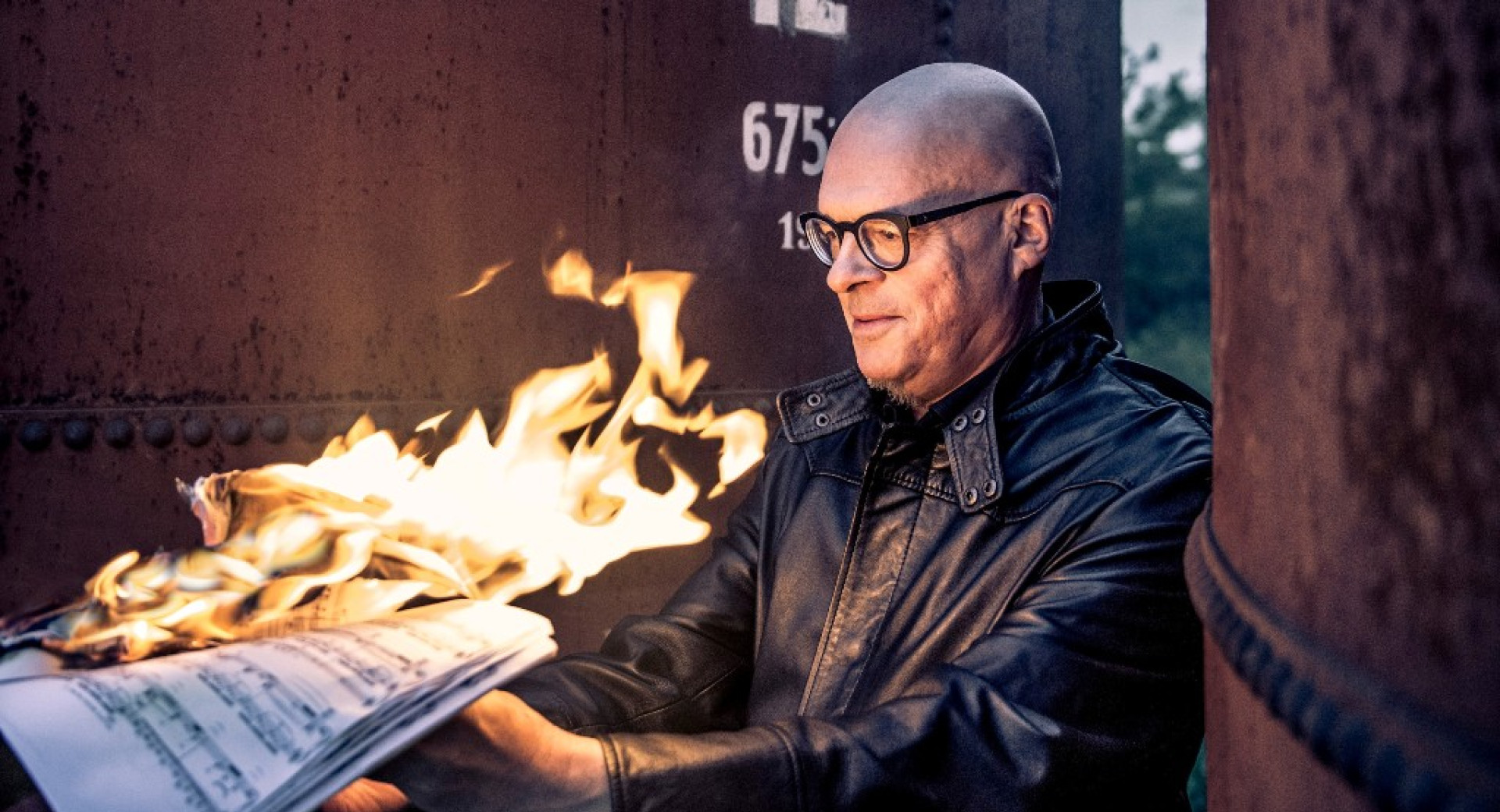 Man holding burning notes.