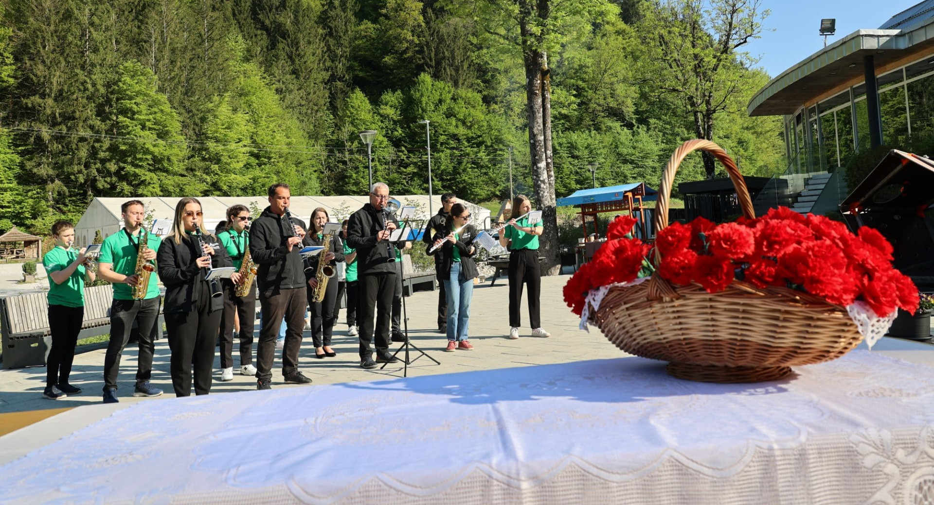 Kosara rdecega cvetja v ospredju, godba v ozadju.