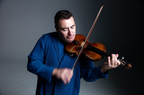 Moski v modri obleki igra na violino.